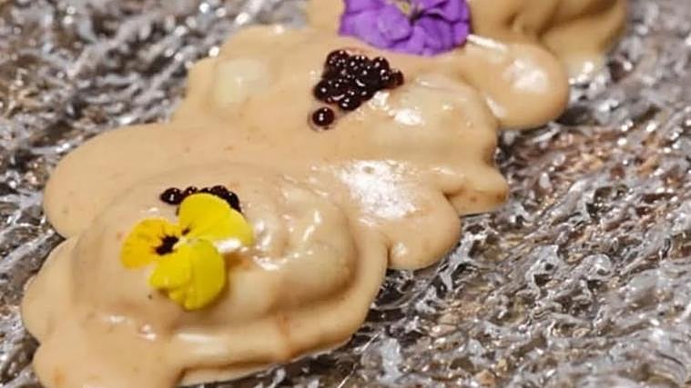 Sorrentino relleno de mozzarella, membrillo y parmesano con salsa de queso y nueces del restaurante La Bicicleta Pizzería