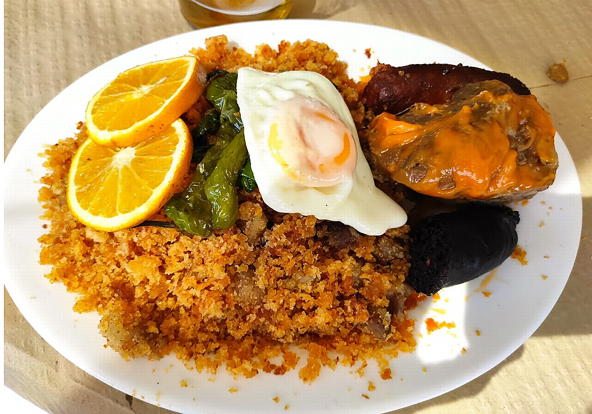 Migas con huevo, pimientos y lomo en manteca, un plato típico de la Venta El Boticario, en Málaga