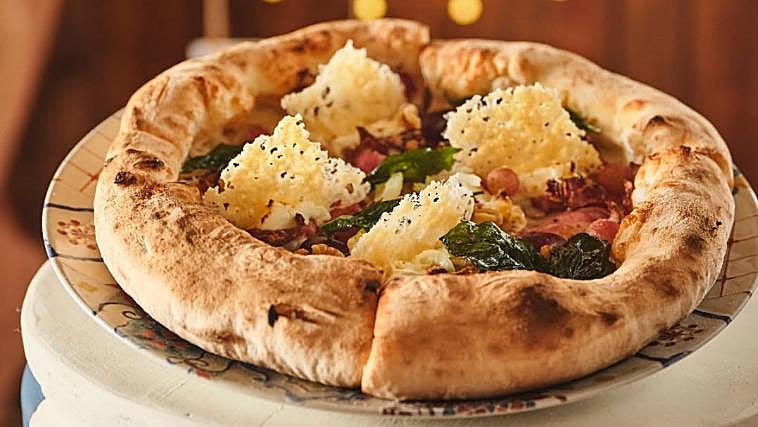Pizza Circus de La Bicicleta, candidata a Mejor Pizza de España, con base de mozzarella, mezcla de quesos con gorgonzola, copa italiana y guanciale, uvas, miel, nueces, mascarpone y crujiente de parmesano