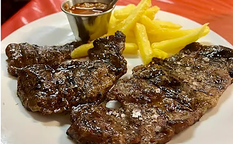 Imagen principal - Carne a la brasa, salón interior y espinacas con garbanzos de Taberna Justicia, en Umbrete