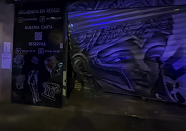 La puerta de Athena Bar, destrozada tras sufrir un alunizaje