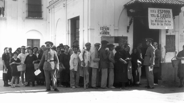 Recogida de alimentos en Sevilla, con la cartilla de racionamiento, en junio de 1940