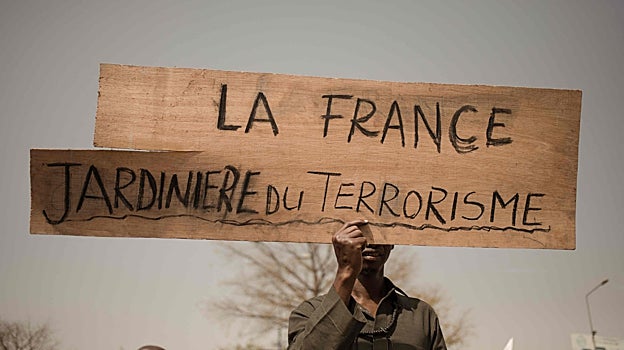 Un maliense con una pancarta con el mensaje «Francia, jardinera del terrorismo»