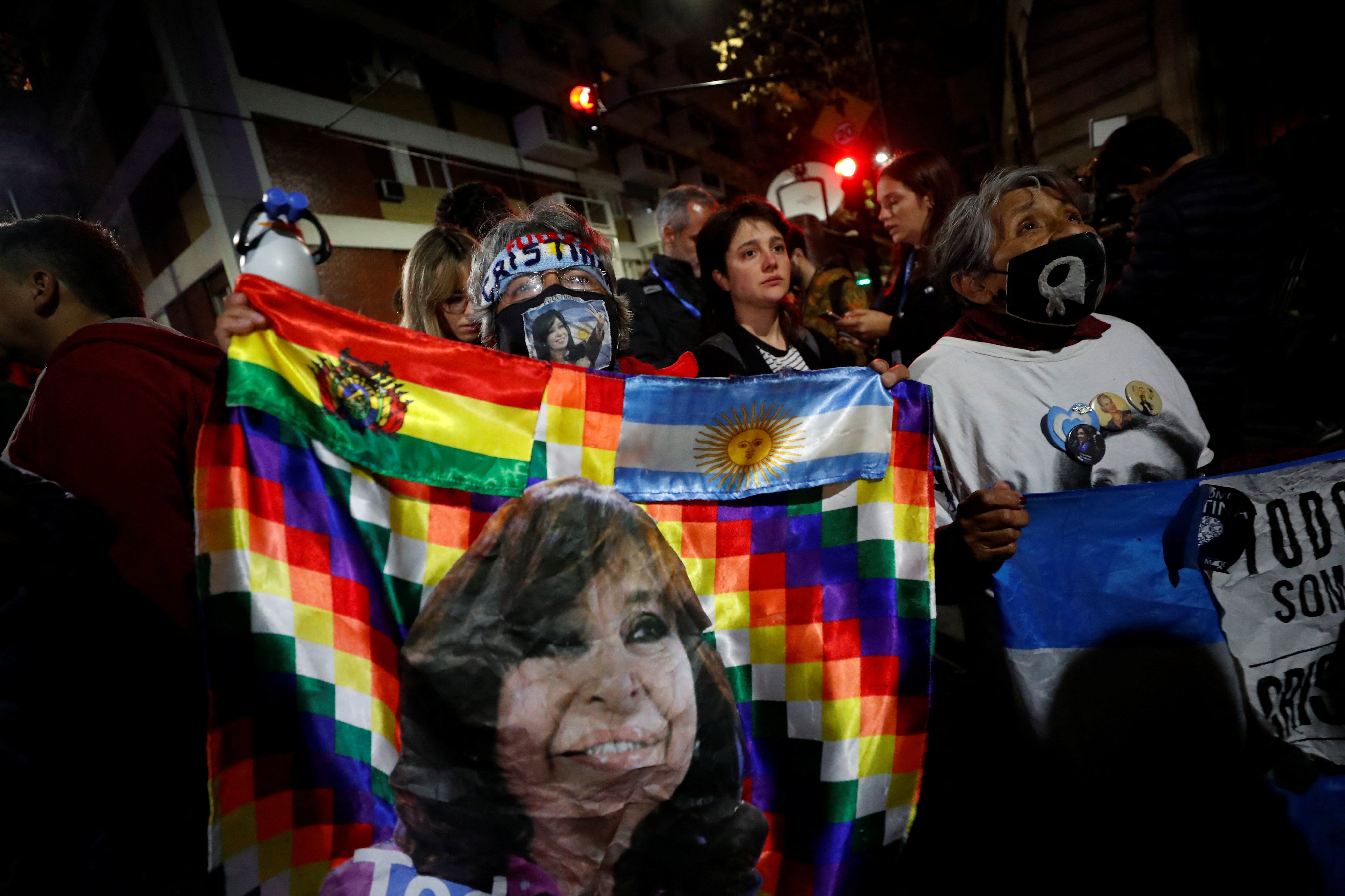 Una partidaria de Kirchner sostiene una bandera indígena con el rostro de la vicepresidenta en la concentración en su apoyo. 