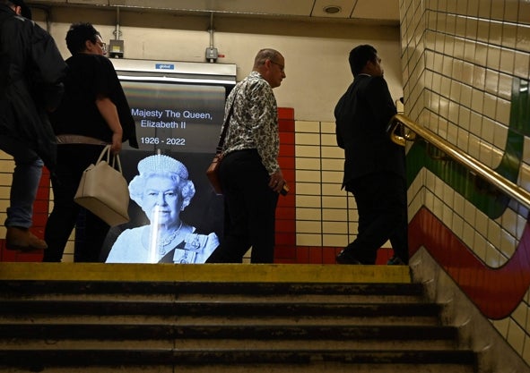 Imagen secundaria 1 - Desde los alrededores del Palacio de Buckingham, donde se congregaron cientos de personas, hasta el metro, e incluso los pubs, la muerte de la Reina copó ayer la vida del pueblo británico