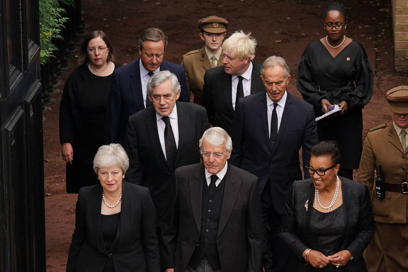 Desde el frente, de izq. a dcha: los antiguos primeros ministros Theresa May, John Major y Patricia Scotland. Segunda fila: Antiguos primeros ministros Gordon Brown y Tony Blair. Tercera fila: antiguos primeros ministros David Cameron y Boris Johnson a su llegada en el palacio de St. James