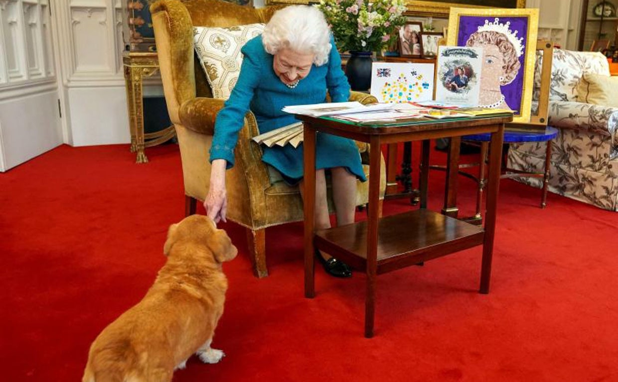 La Reina Isabel II de Gran Bretaña acariciando a Candy, su perro corgi en febrero de 2022