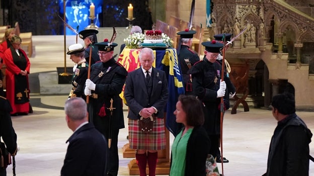 Miembros del público pasan mientras el Rey Carlos III de Gran Bretaña, la Princesa Ana, el Príncipe Eduardo y el Príncipe Andrés asisten a una vigilia en la catedral de San Giles, en Edimburgo