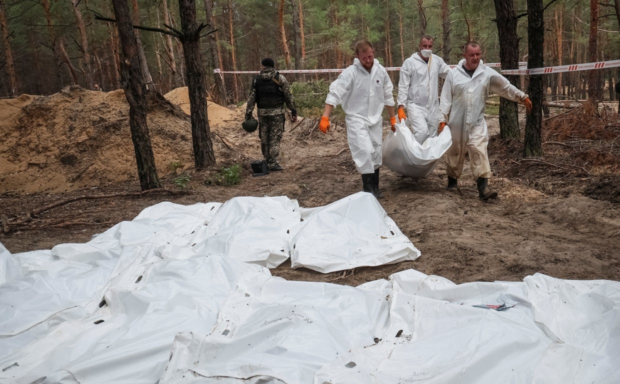 Los forenses trasladan los cuerpos hallados en la fosa común de Izium, al este de Ucrania