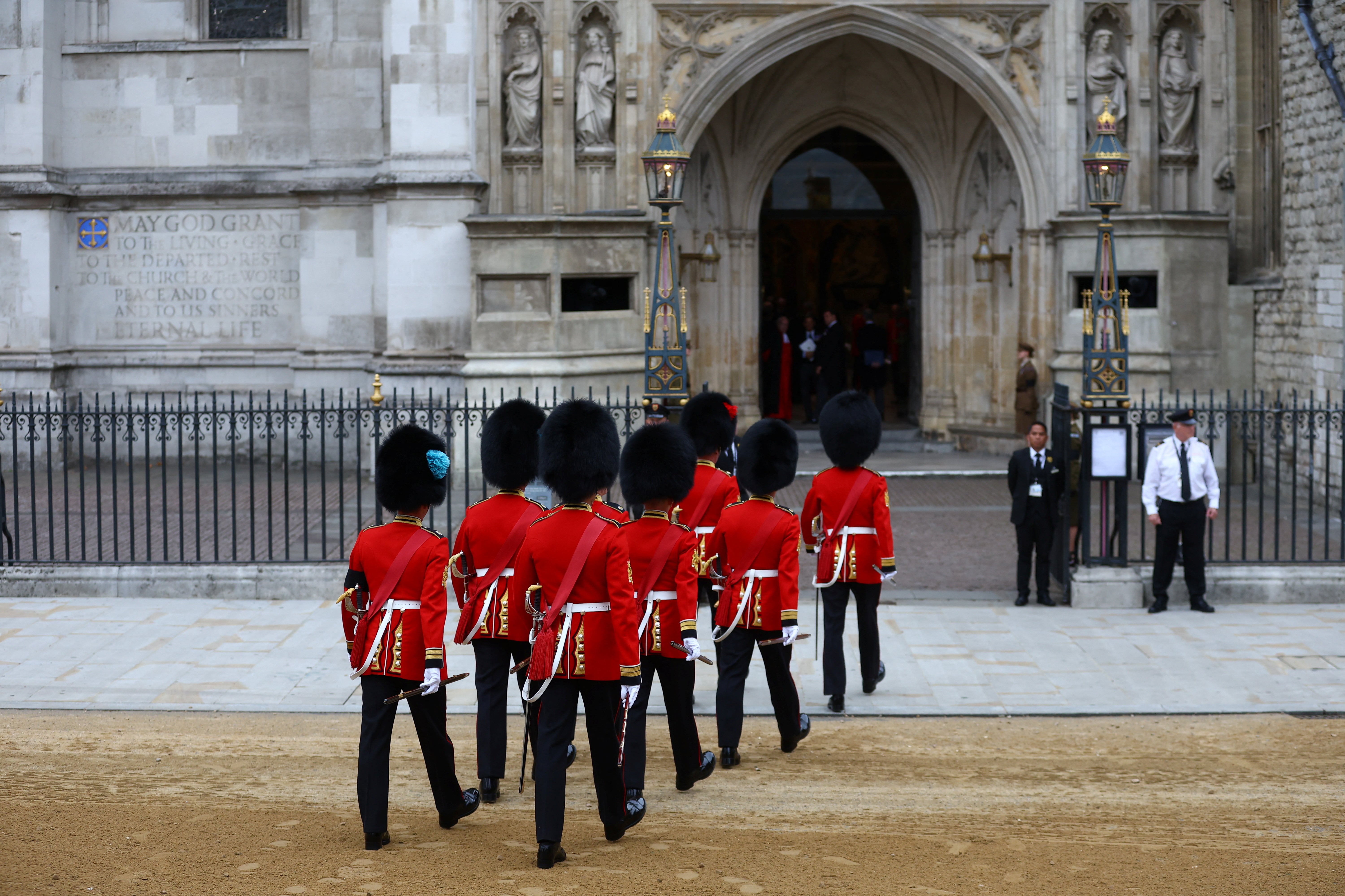 Soldados uniformados pasan al interior de la abadía de Westminster. 
