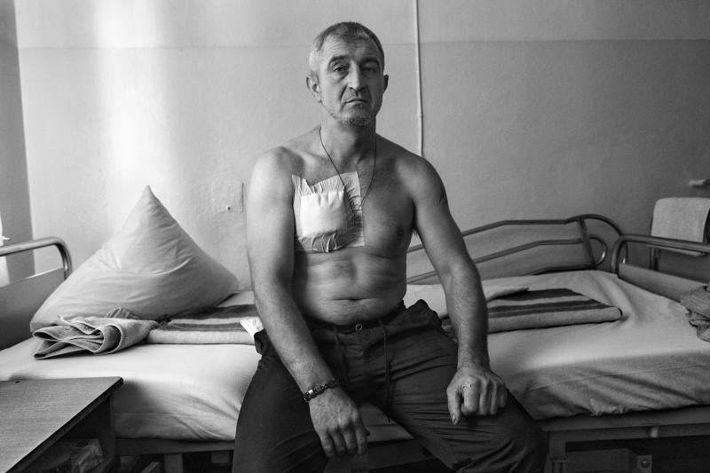 Mykola posa en la cama de un hospital de la ciudad de Mykolaiv mientras se recupera de una herida de esquirla. Es voluntario militar. Se alistó al Ejercito el pasado 1 de marzo tras el inicio de la invasión rusa. Anteriormente era mecánico de ferrocarriles. Hoy forma parte de una unidad de artillería en el frente de Jersón