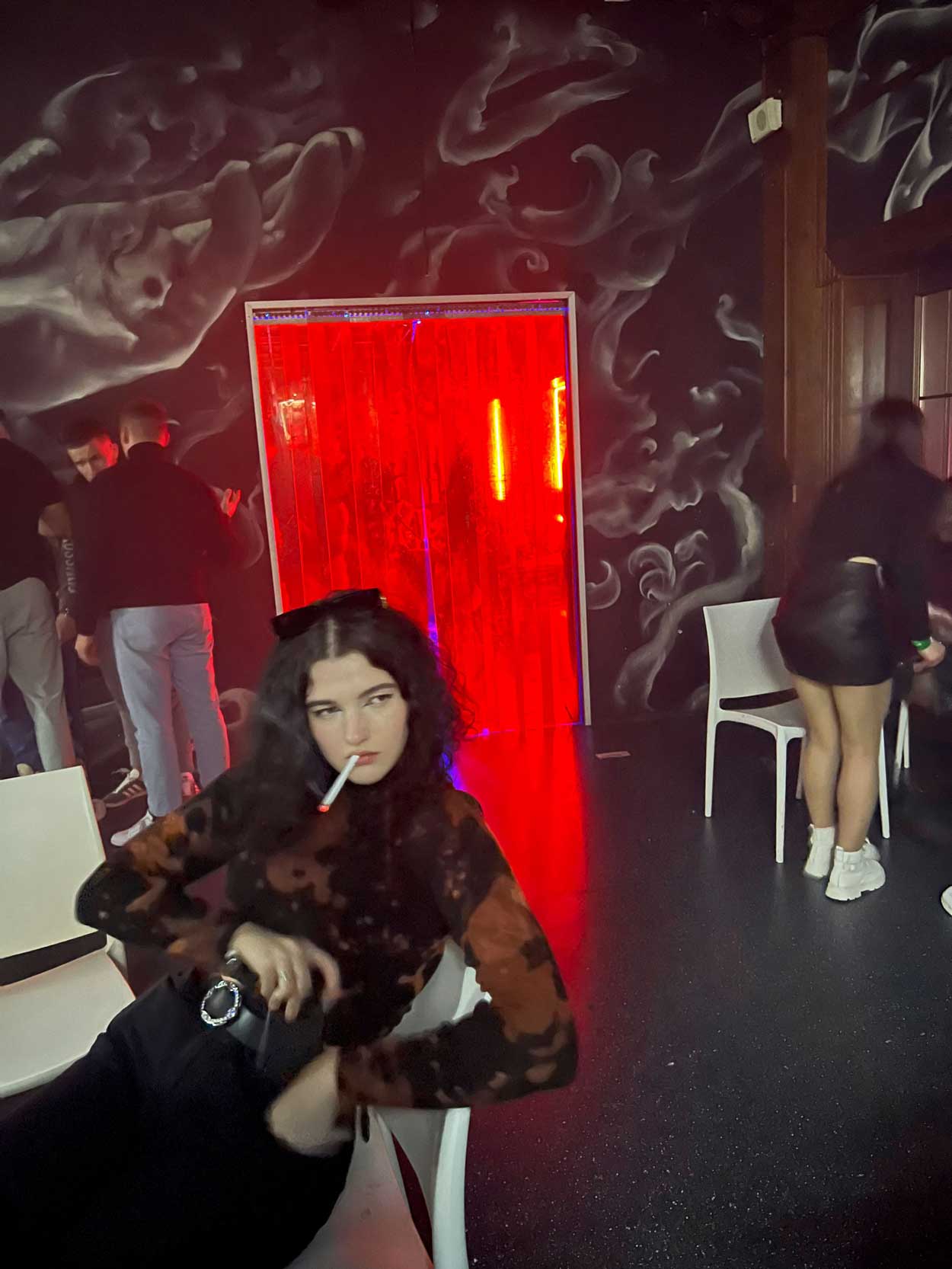 Una mujer fuma en un local nocturno