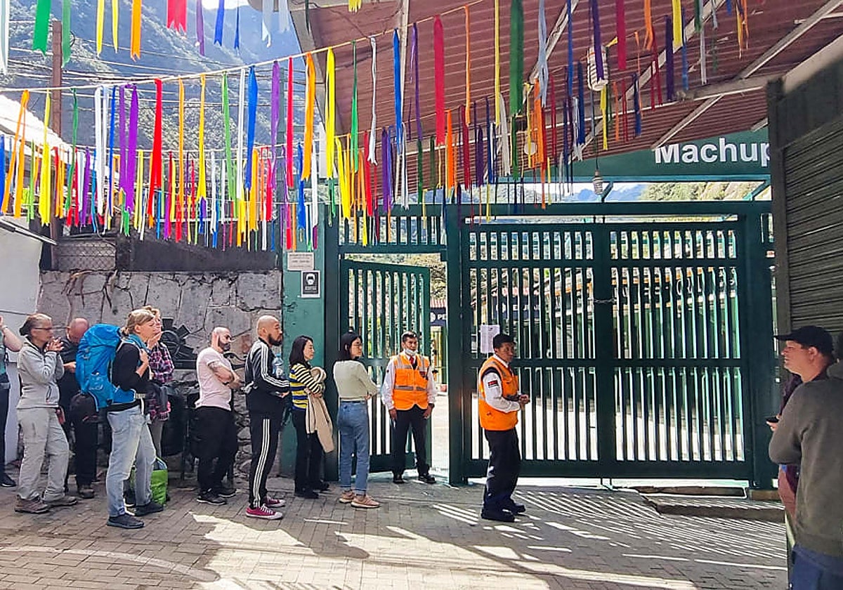 Turistas esperan para poder acceder a la estación de tren de Machu Picchu, cerrada