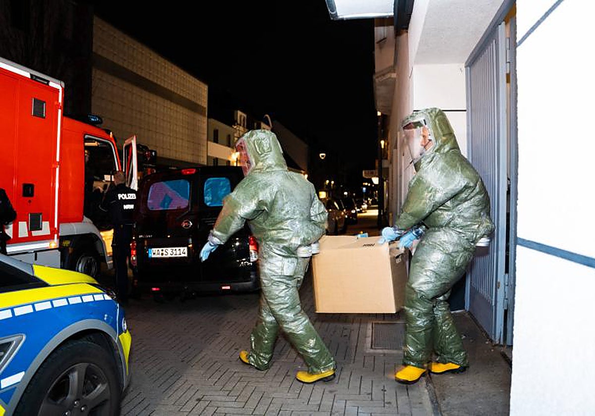 Agentes con trajes protectores sacan una caja de un apartamento en Castrop-Rauxel, Alemania occidental, tras los arrestos de dos iraníes sospechosos de preparar un atentado con cianuro y ricina