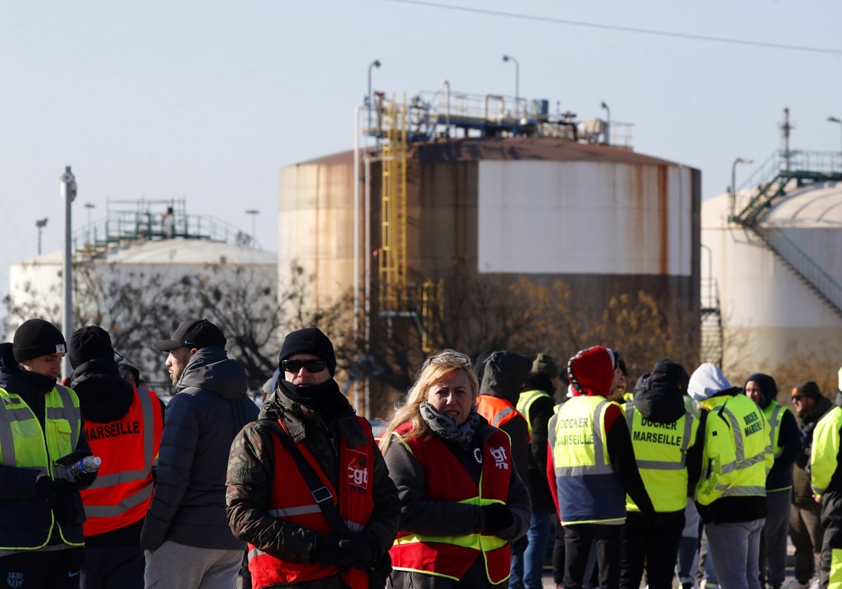 Manifestantes de CGT Energía y estibadores de pie y con banderas durante una jornada de huelga nacional de refinerías y puertos contra la reforma del sistema de pensiones del Gobierno, en Martigues, sur de Francia.