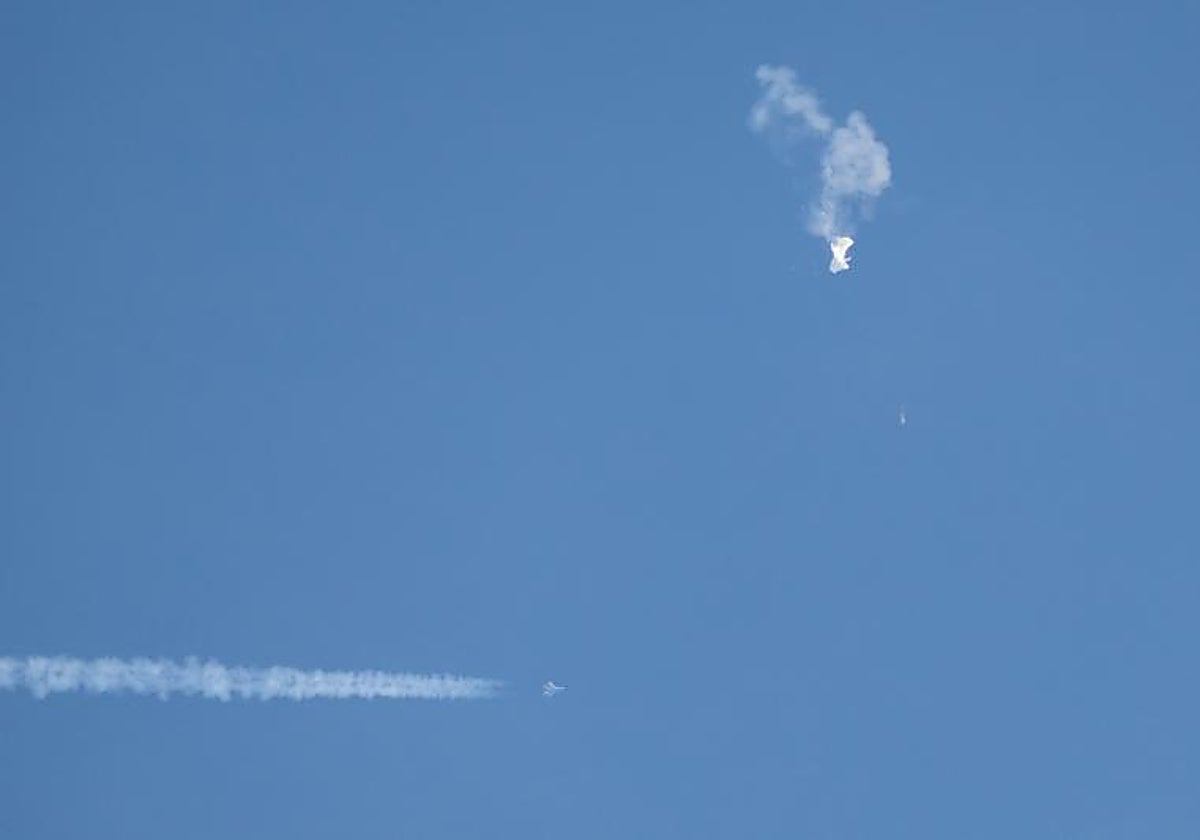 Un avión comercial (i) vuela por debajo del 'globo espía' chino