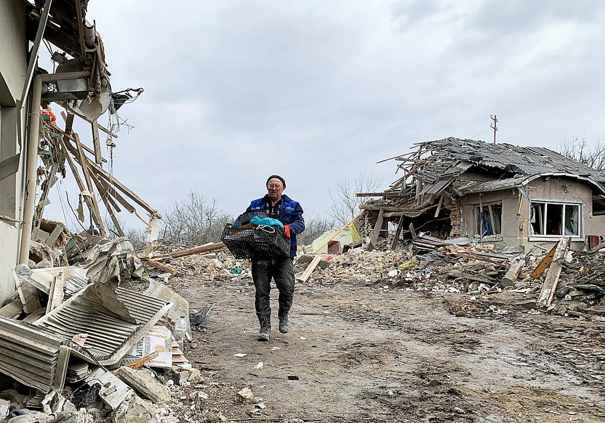 Un hombre camina entre los escombros provocados por la caída de un misil ruso cerca de Leópolis