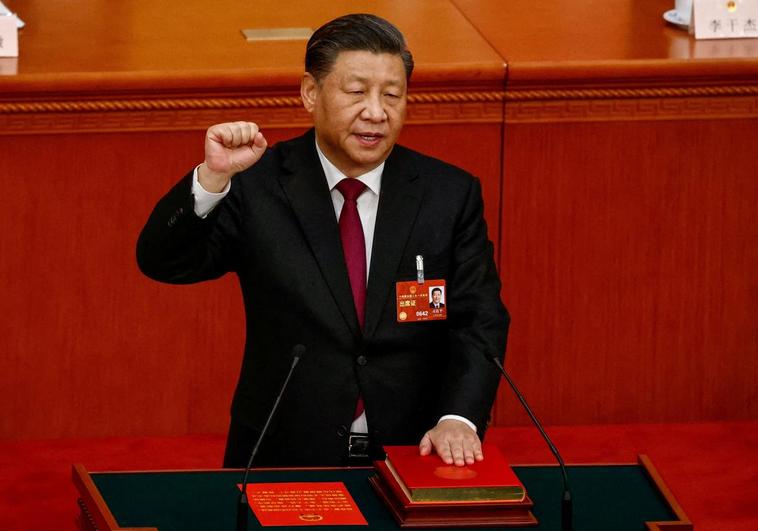 Chinese President Xi Jinping raises his fist during the pledge of office in the country's Magna Carta