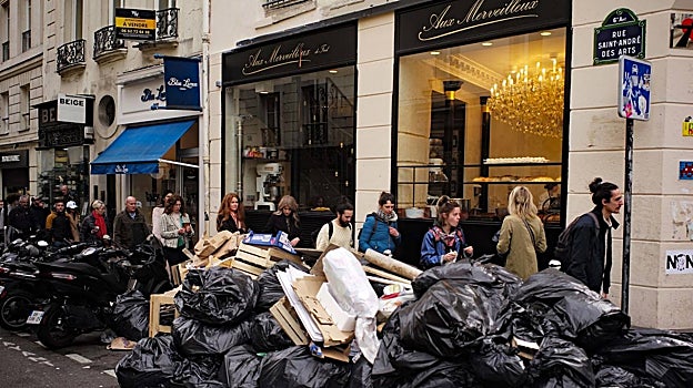 Más basura apilada frente a la pastelería Aux Merveilleux