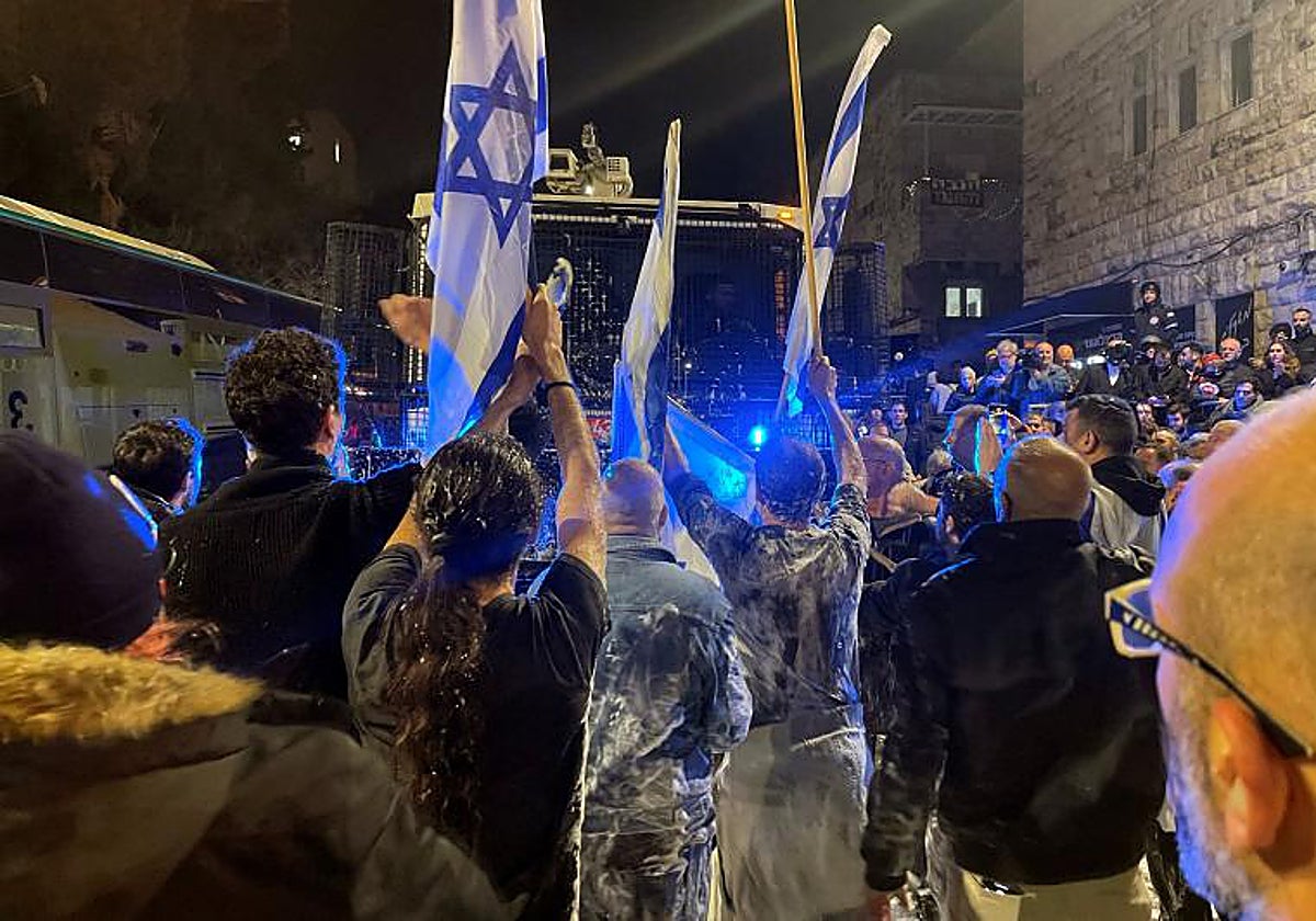 Los manifestantes reaccionan después de ser rociados por un cañón de agua mientras se manifiestan en la casa privada del primer ministro israelí Netanyahu.
