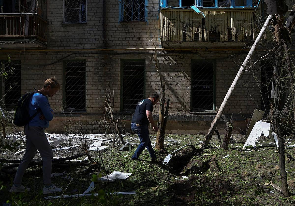 Residentes ucranianos revisando los destrozos de un ataque ruso en Jersón.