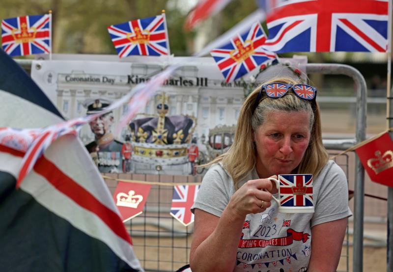 Una fan de la familia real bebe una taza de té mientras espera en The Mall en Londres.