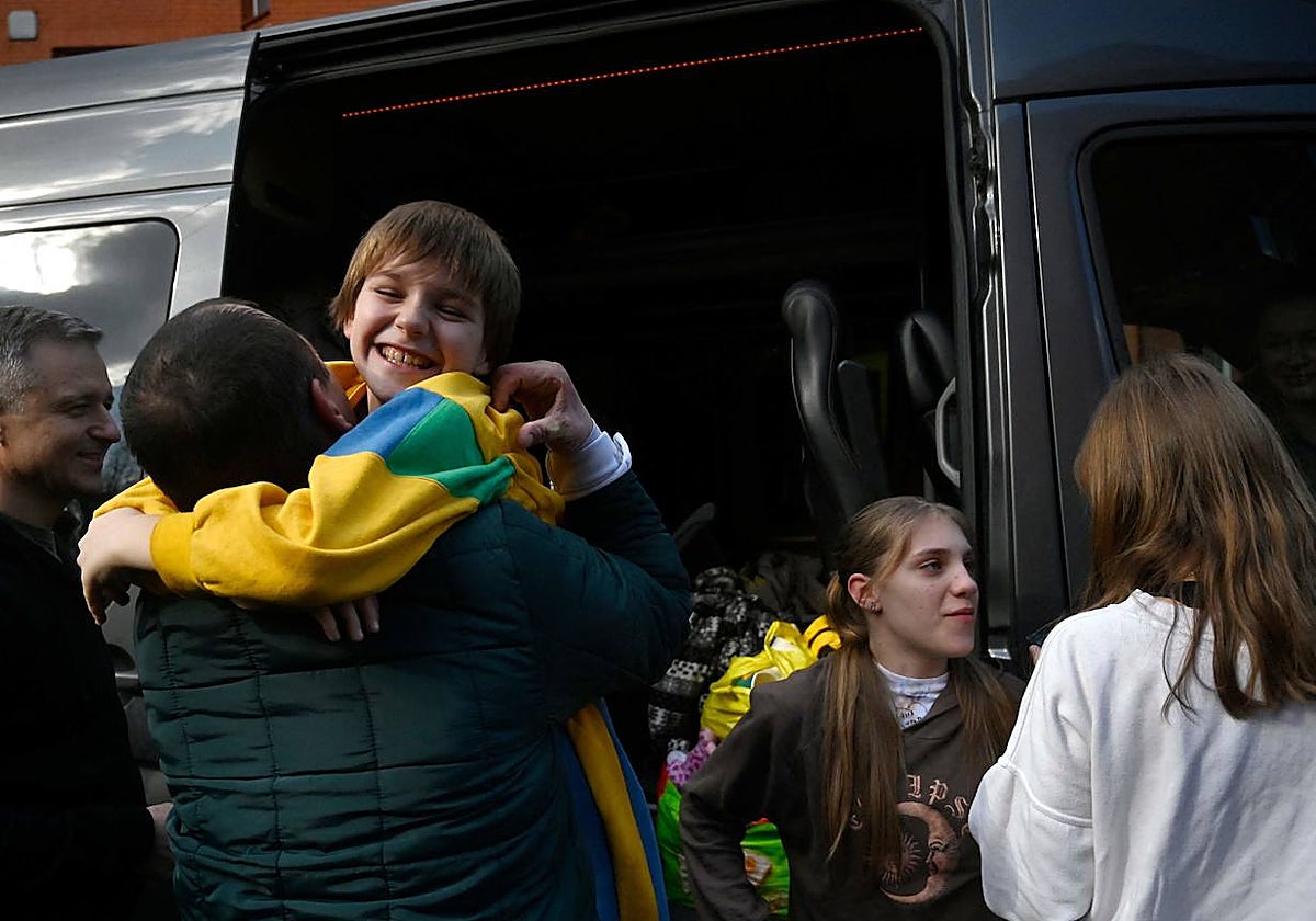 Un hombre abraza en Kiev a su hijo, separado de la familia al quedar atrapado en zona controlada por Rusia