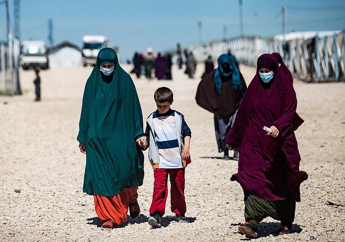 Foto de archivo: mujeres con niños caminan en Camp Roj, donde se encuentran detenidos familiares de personas sospechosas de pertenecer al grupo Estado Islámico (EI).