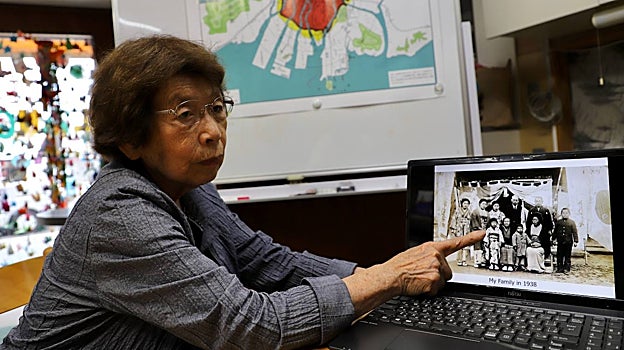 Sadae Kasaoka, que tenía 12 años cuando Estados Unidos lanzó la bomba atómica sobre Hiroshima y perdió a sus dos padres, muestra una foto de su familia años antes del ataque