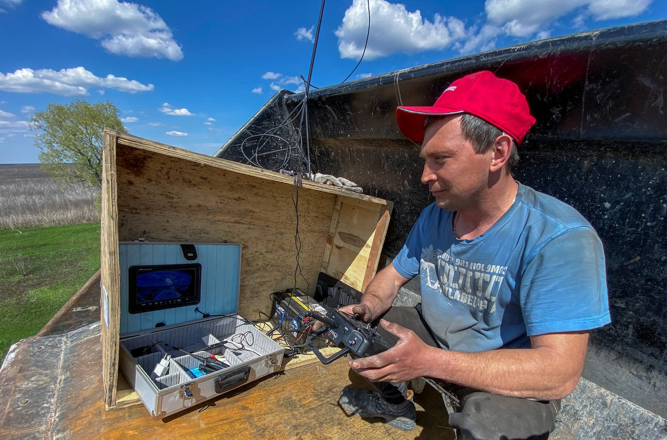 Un trabajador usa un control remoto para operar una máquina de desminado hecha de tractores y placas blindadas de vehículos militares rusos destruidos en un campo cerca del pueblo de Hrakove