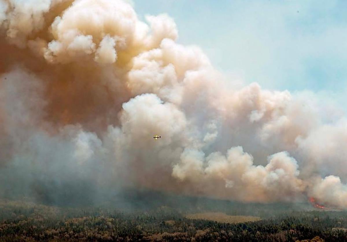 Un avión arroja una mezcla de agua y retardante de fuego sobre el incendio forestal en Nueva Escocia