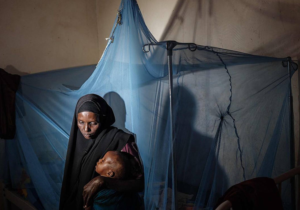 Una mujer sostiene a su hijo en Somalia, una tierra golpeada por las hambrunas