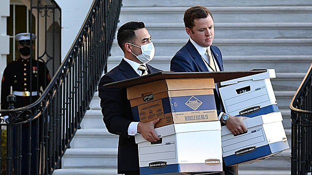 Una foto del 20 de enero de 2021 muestra a los ayudantes que llevan cajas a Marine One antes de que el presidente de los Estados Unidos, Donald Trump , y su esposa Melania Trump partieran de la Casa Blanca el último día de Trump en el cargo, en Washington, DC