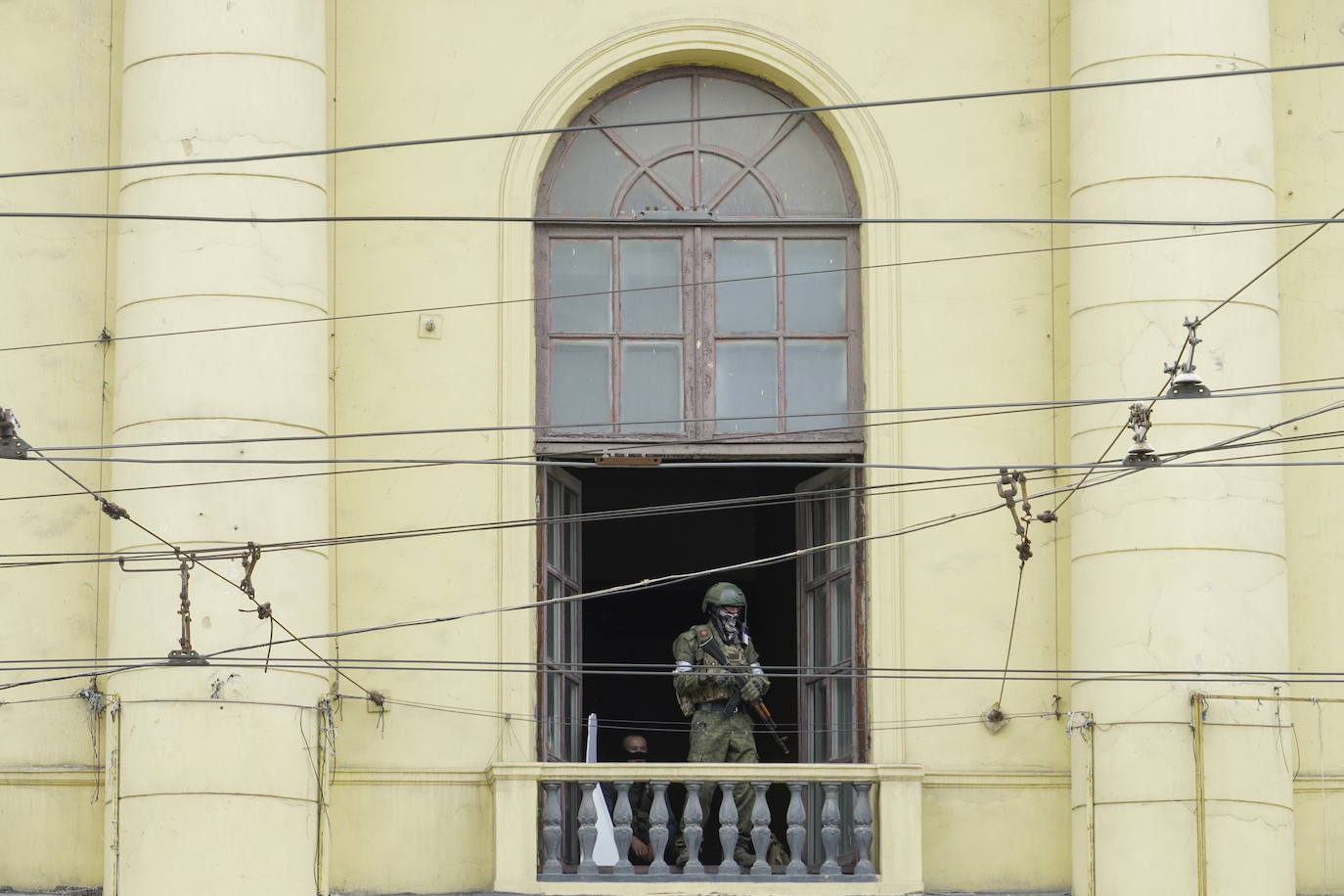 Un militar de la compañía militar privada del grupo Wagner hace guardia en el balcón del edificio de la sede del Distrito Militar Sur en Rostov