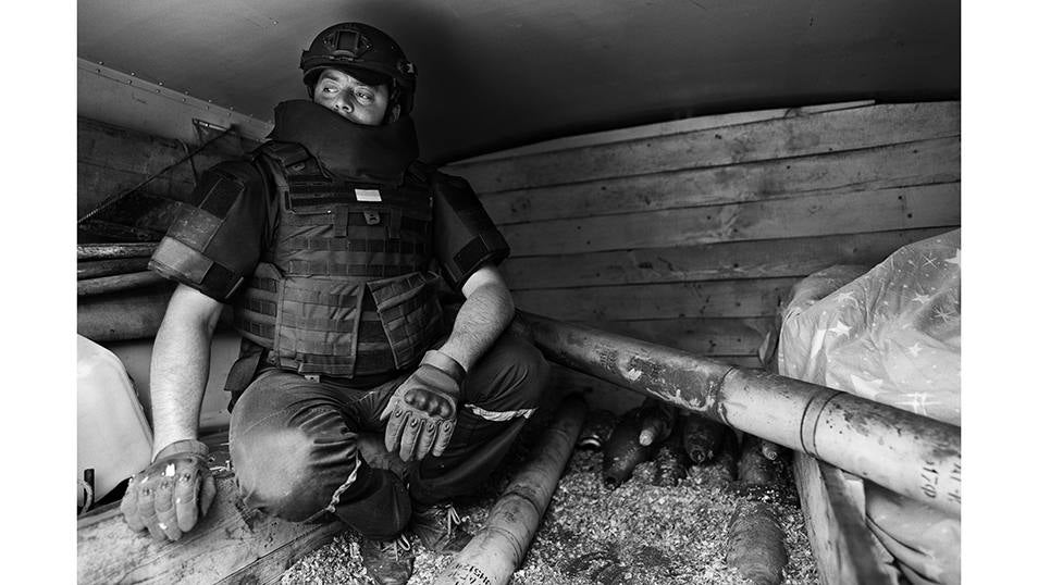Oleksiy espera sentado junto a pila de obuses rusos sin estallar en el interior del camión blindado de su unidad de desminado de los servicios de emergencia de Ucrania.