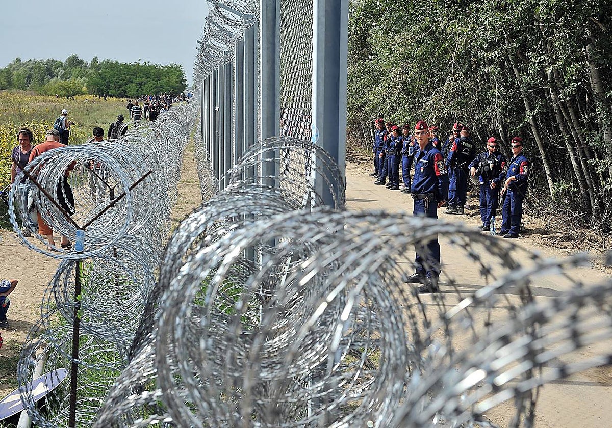 Migrantes y refugiados caminan cerca del cruce fronterizo oficial entre Serbia y Hungría