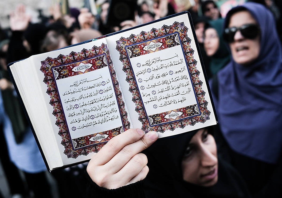 Un manifestante sostiene una copia del Corán mientras asiste a una protesta frente al Consulado General de Suecia