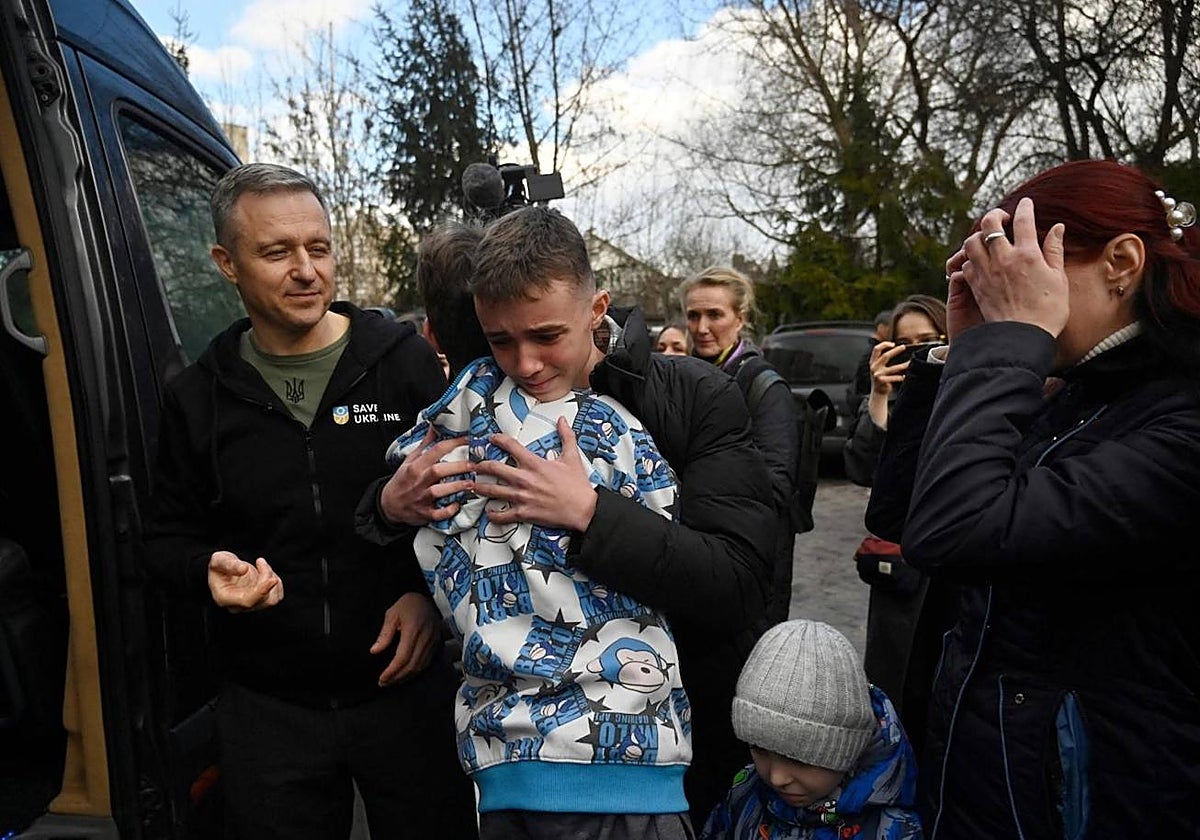 Inessa (derecha) se encuentra con su hijo Vitaly después de que el autobús que lo traía a él y a más de una docena de otros niños que regresaban del territorio controlado por Rusia llegara a Kiev, en marzo de 2023