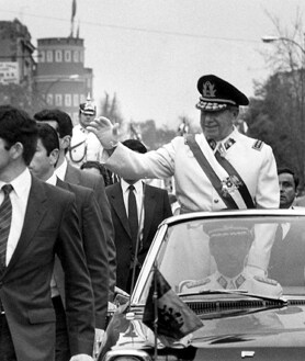 Imagen secundaria 2 - Soldados y bomberos cargan el cuerpo del presidente Salvador Allende, envuelto en un poncho boliviano, fuera del destruido palacio presidencial de La Moneda después del golpe encabezado por el general Augusto Pinochet que puso fin al gobierno de tres años de Allende