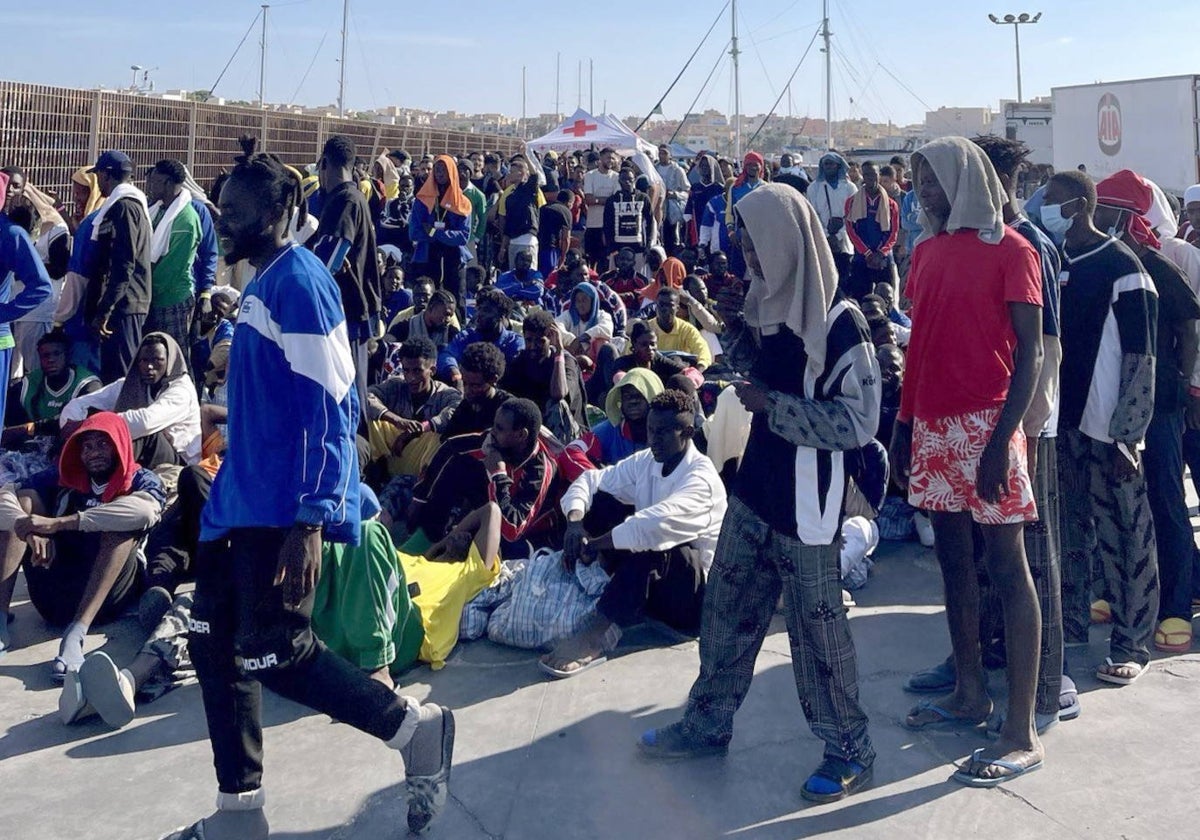 Un grupo de migrantes espera en la isla de Lampedusa mientras las autoridades italianas se preparan para trasladar a las personas tras las nuevas llegadas