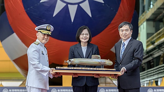 La presidenta de Taiwán, Tsai Ing-wen (C), posando con la maqueta de un prototipo de submarino durante la ceremonia de botadura del primer submarino de fabricación nacional de Taiwán