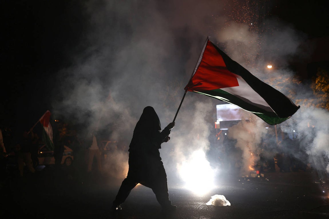 Una mujer iraní sostiene una bandera palestina durante una concentración de apoyo a los palestinos, en Teherán, Irán, el 7 de octubre.