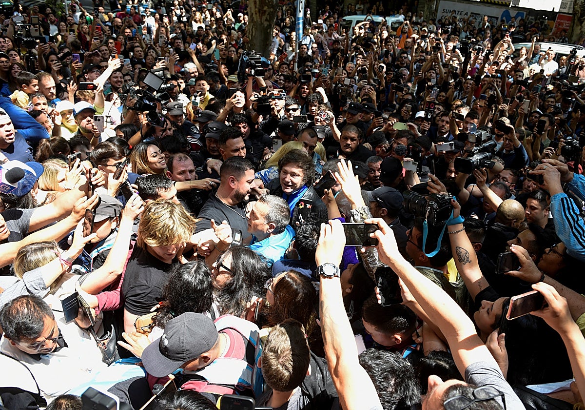 El candidato a la Presidencia de Argentina Javier Milei saluda a sus simpatizantes, a la salida de un colegio electoral