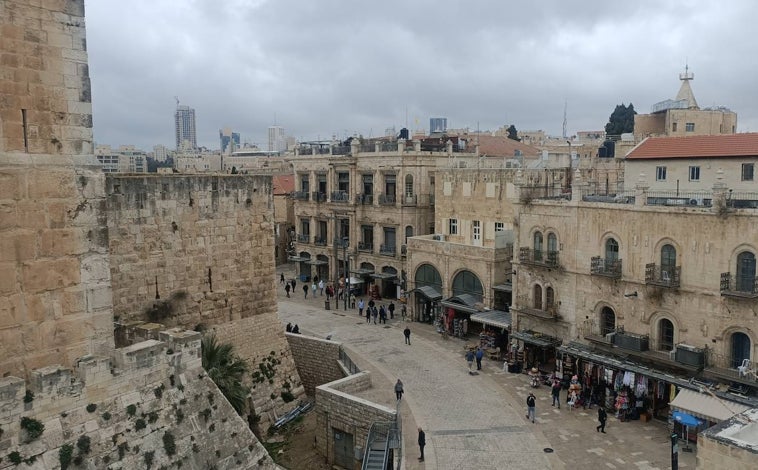 Imagen principal - En la foto superior, la Ciudad Vieja de Jerusalén, cerca de la Puerta de Jaffa. Debajo, el río Jordán como frontera: a la izquierda, Israel; a la derecha, Jordania, en el sitio del bautismo de Jesús. Por último, el zoco de Jerusalén con los comercios cerrados, sin turistas