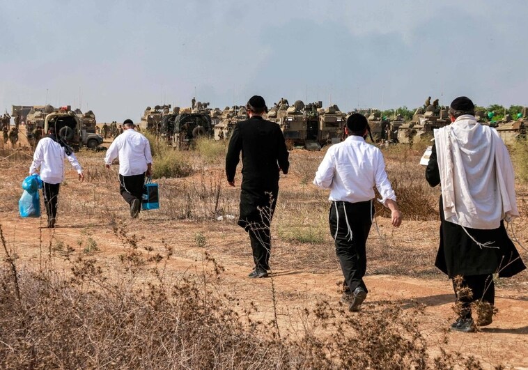 Los judíos ultraortodoxos visitan a los soldados del ejército israelí para mostrar su apoyo mientras se despliegan en una posición cerca de la frontera con Gaza en el sur de Israel el 11 de octubre de 2023