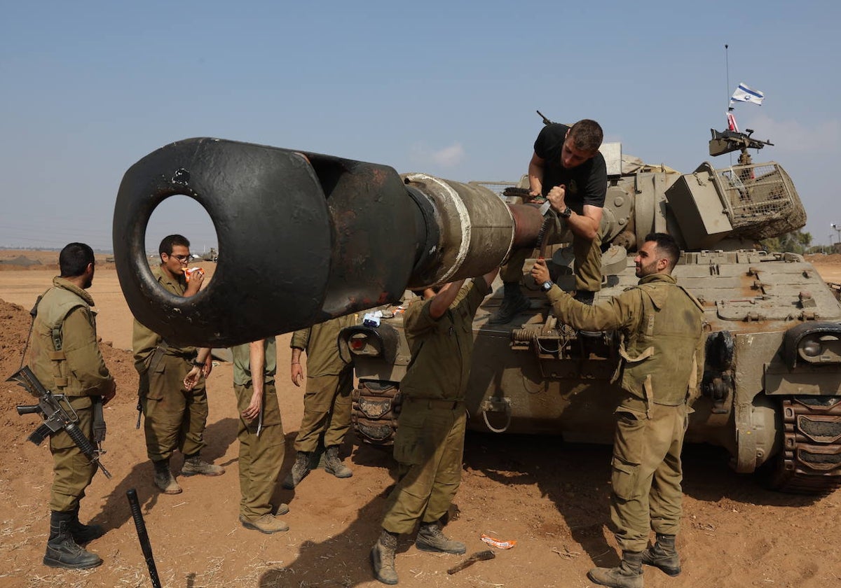 Un grupo de soldados israelíes de una unidad de artillería revisa el cañón de un carro de combate cerca de la frontera con Gaza, en el sur de Israel