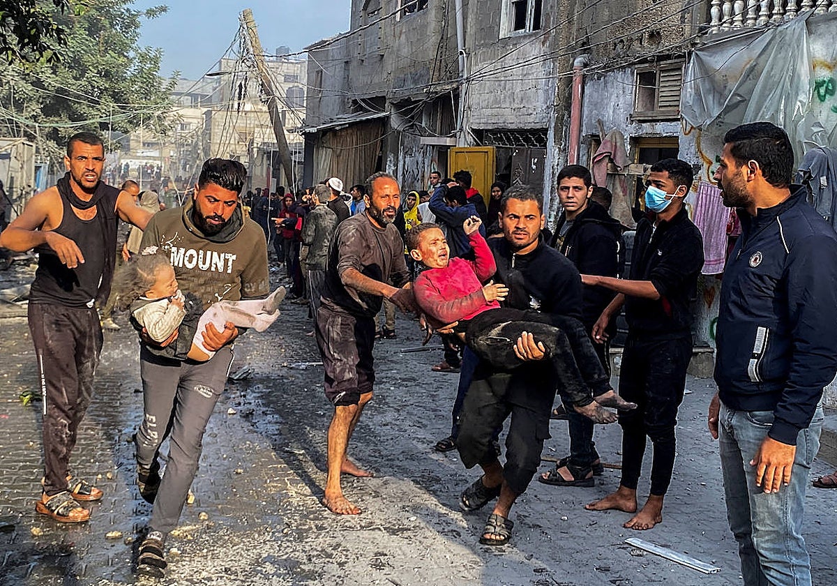 Varios palestinos llevan a niños heridos tras un ataque israelí contra una casa, después de que expirara una tregua temporal entre Hamás e Israel