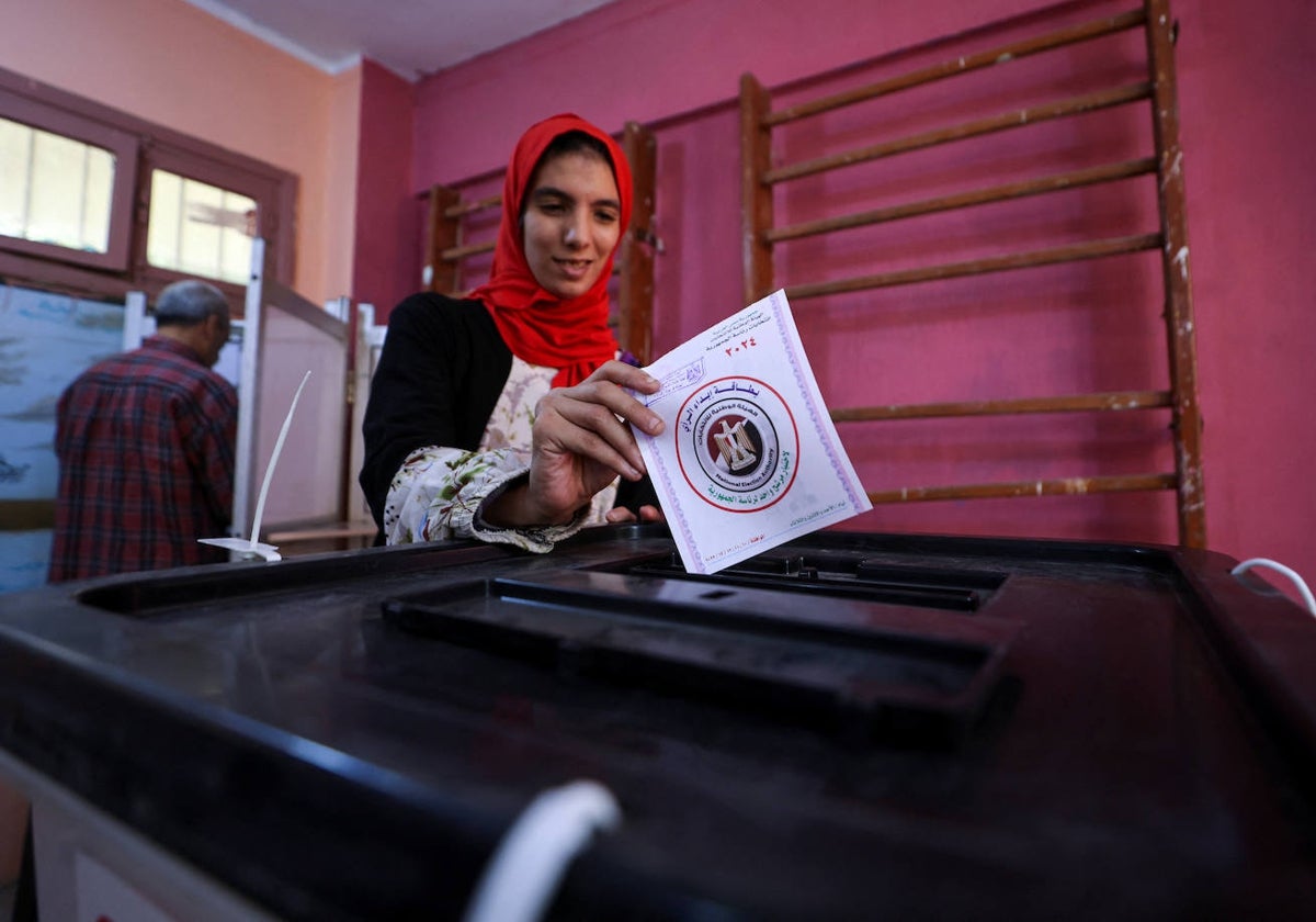 Una mujer vota en una mesa electoral, el segundo día de las elecciones presidenciales en Giza, Egipto