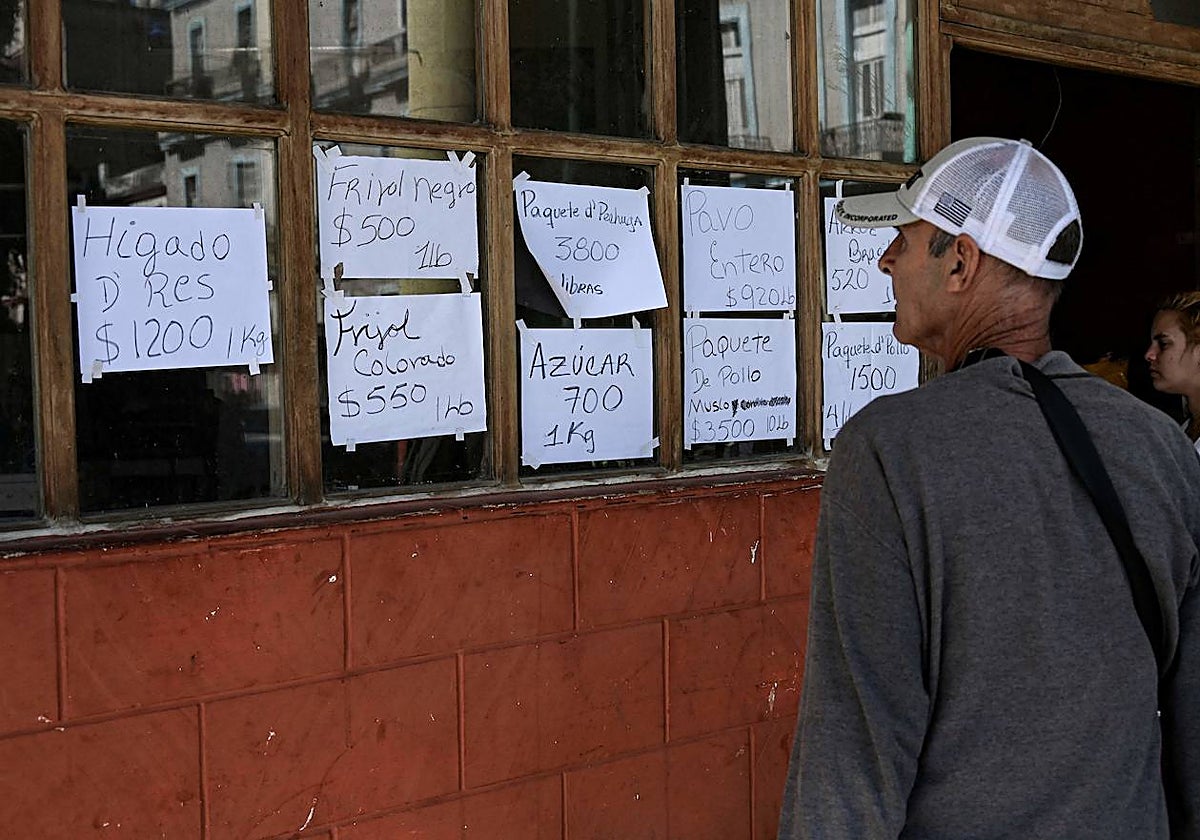 Un hombre mira los precios de los alimentos en un establecimiento en La Habana