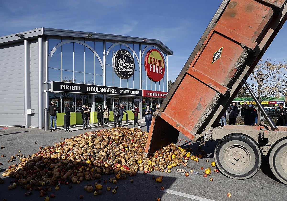 Un camión descarga frutas y verduras frente a un supermercado en Francia